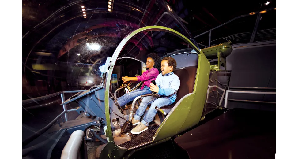 Woman and boy having fun at the Helicopter located at the Exploreum, interactive zone.