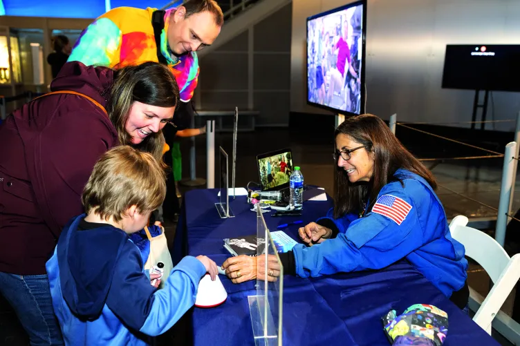 A family is interacting with a Museum educator