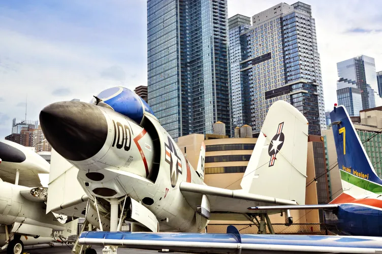 Planes on the flight deck with New York City in the background