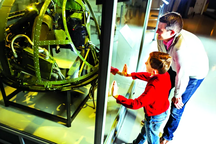 A parent and child are looking at an aircraft