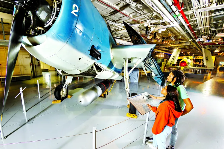 A parent and child are looking at an aircraft