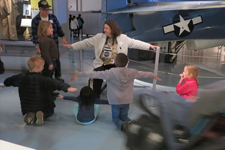 An educator instructing children at the USS Intrepid museum