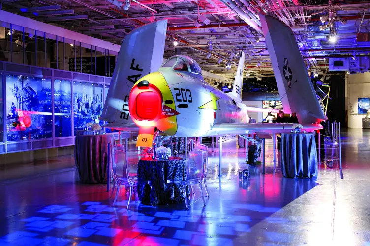 Bistro tables set up for an event on the hangar deck