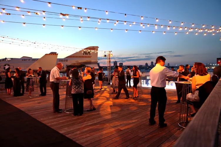 Guests mingling at an event on the port side aircraft elevator
