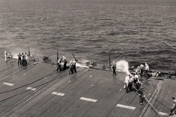 Crew members fight fires in Gun Tub 10 after the kamikaze attack