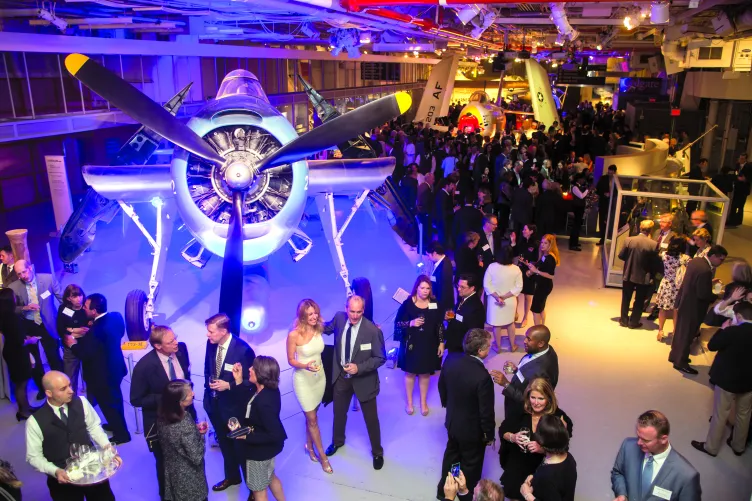 Guests at an event mingling on the hangar deck