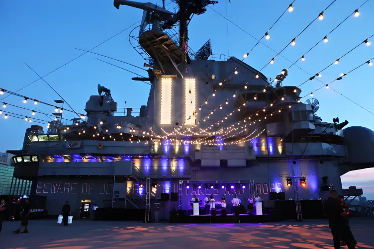 String lighting and uplighting is set with the band on stage with the Flight Deck Island as the backdrop.