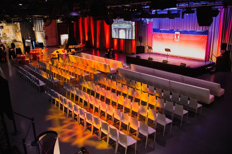 Hangar 3 set for a conference with theater style seating a stage setup AV screens and lighting