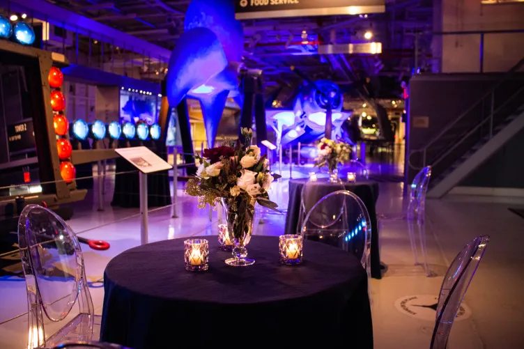 Hangar 1 set up for a reception with low top tables and event lighting