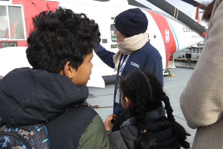 An educator engages with families during an activity at the Intrepid Museum.