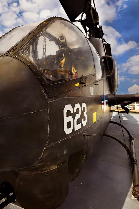 The side of a large black aircraft and a view into the cockpit.