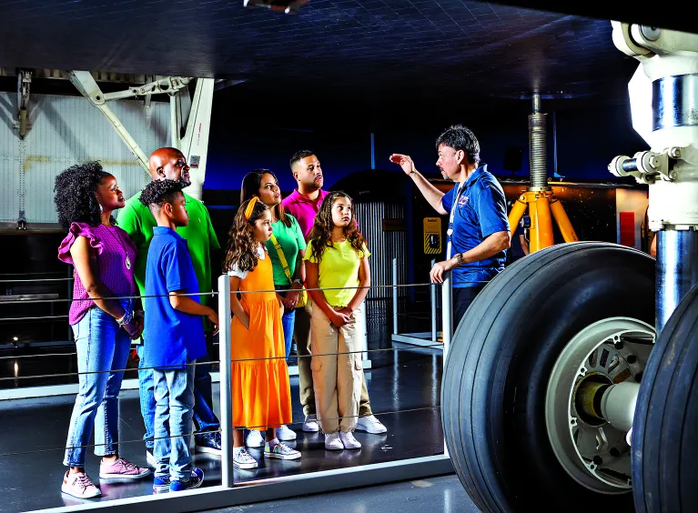 Group of visitors with an educator at the Space Shuttle Pavilion