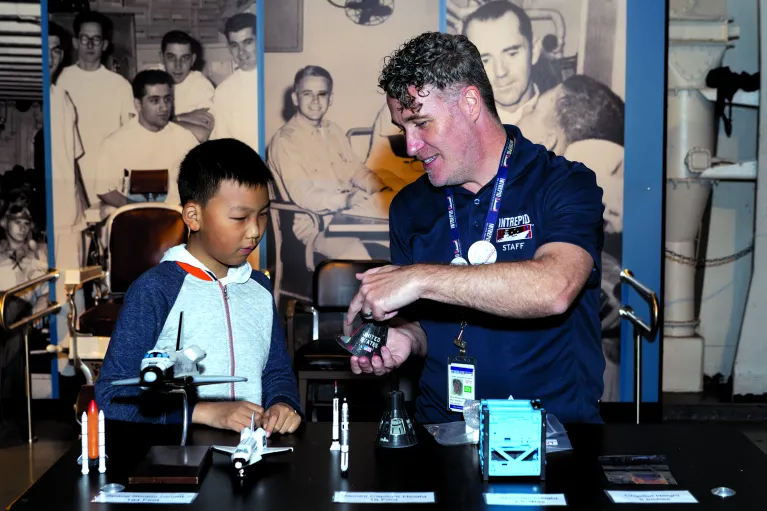 Educator and Boy at an education station at an event night