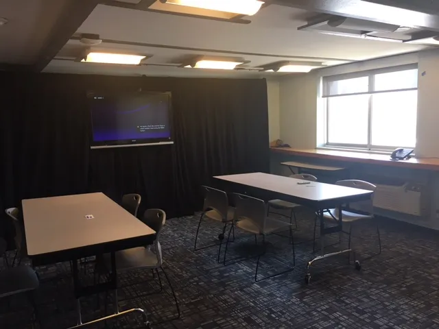 Classroom style setup with pipe and drape, and a monitor screen in the classroom