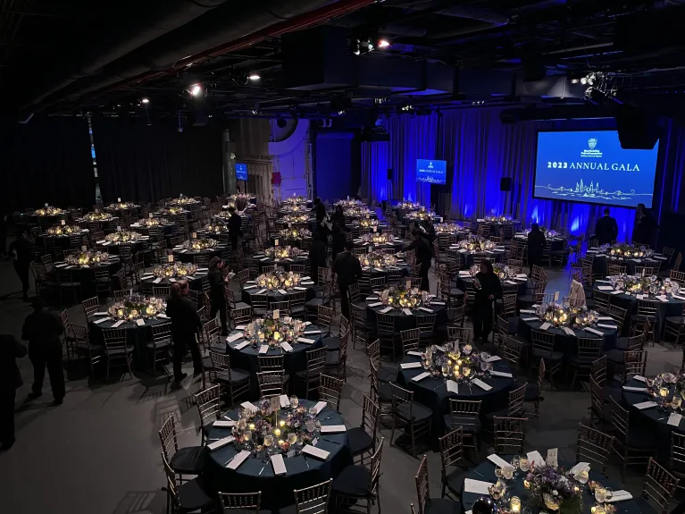 Hangar 3 set for a gala dinner with black linen on dinner tables and blue up lighting