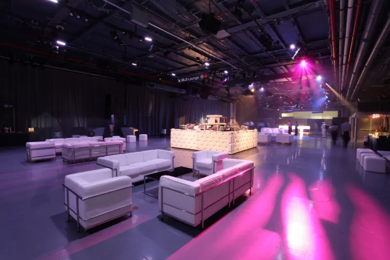 Hangar 3 cocktail reception with lounge furniture, bar, and pink event lighting