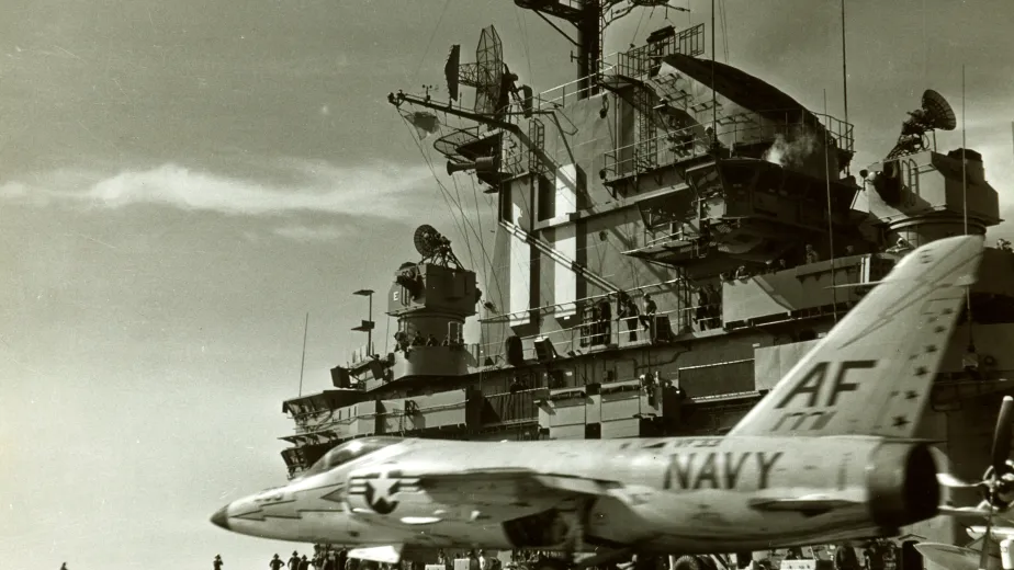 An archival photo of the Intrepid's flight deck with a navy plane on it, about to take off.