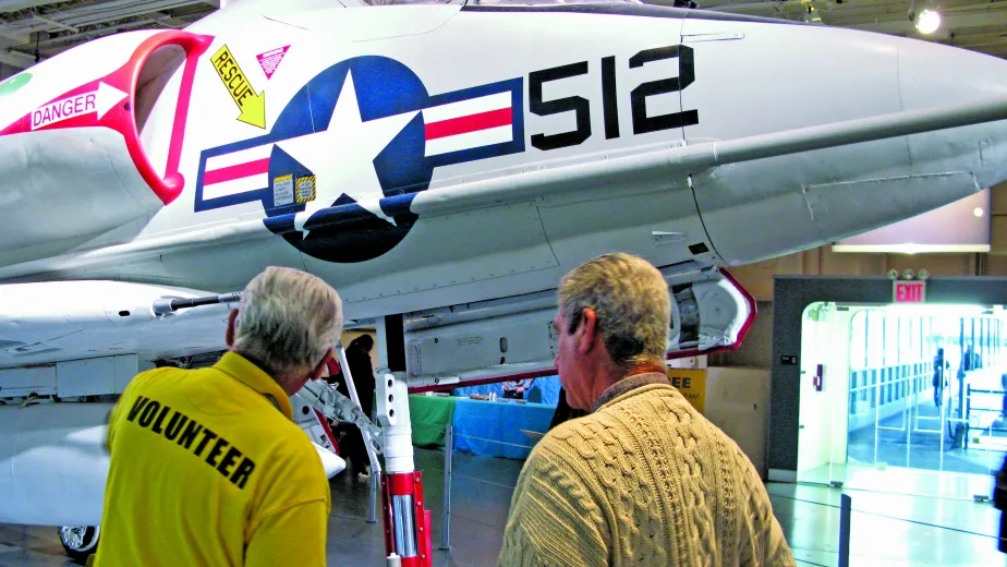 A veteran is speaking with a guest at the Museum.