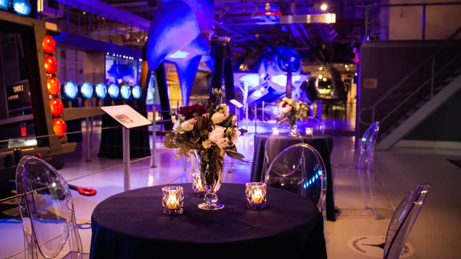 Hangar 1 set up for a reception with low top tables and event lighting